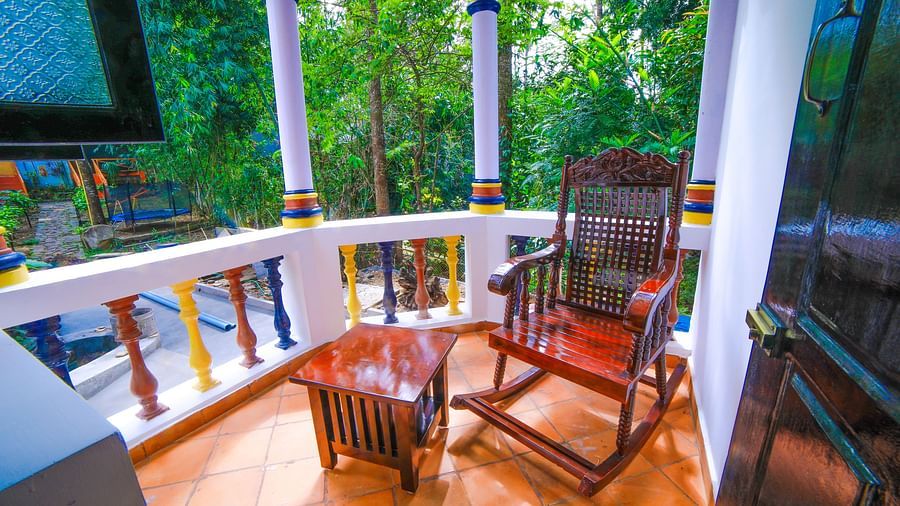 Image of a balcony with a rocking chair and a wooden table in front at WOW Bison Woods.